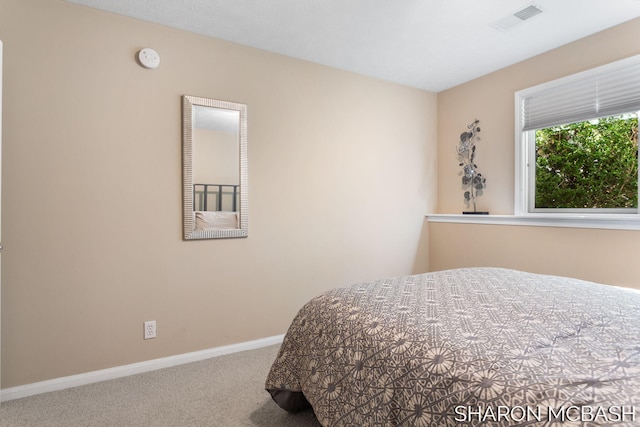 carpeted bedroom featuring visible vents and baseboards