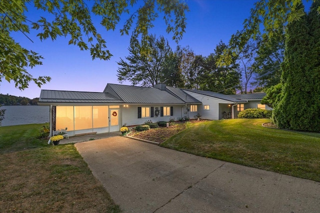 view of front of house featuring metal roof, a front lawn, and a standing seam roof