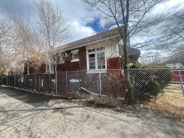 view of side of property with brick siding and a fenced front yard