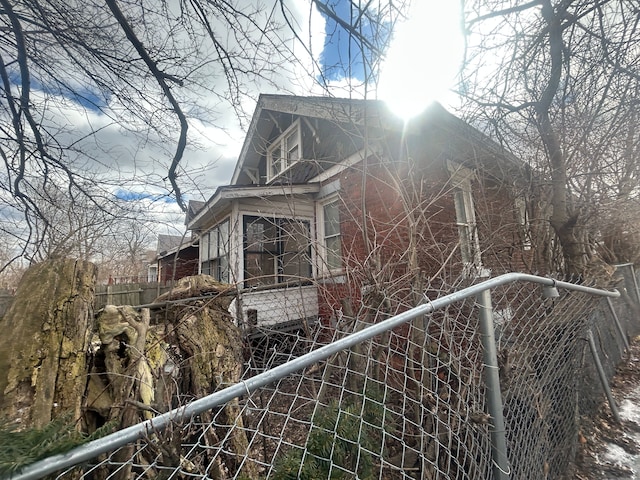 view of home's exterior with fence and brick siding