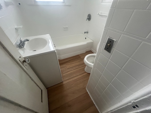 bathroom featuring toilet, vanity, bathtub / shower combination, and wood finished floors