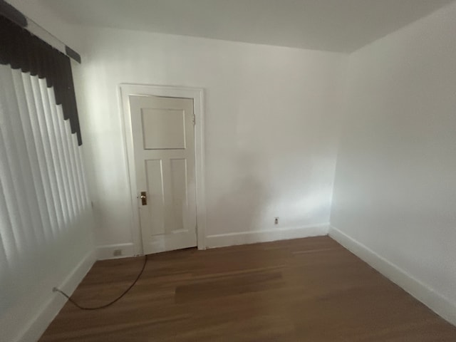 spare room with wood finished floors and baseboards