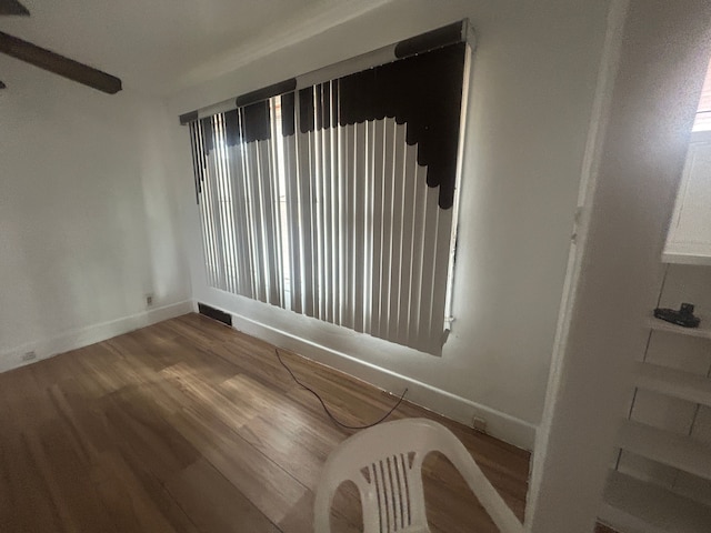 unfurnished room with visible vents, baseboards, and wood finished floors