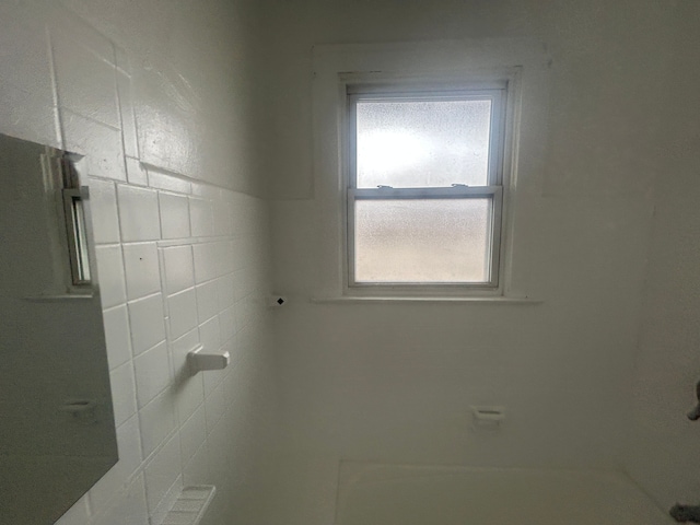 full bathroom with tile walls and walk in shower