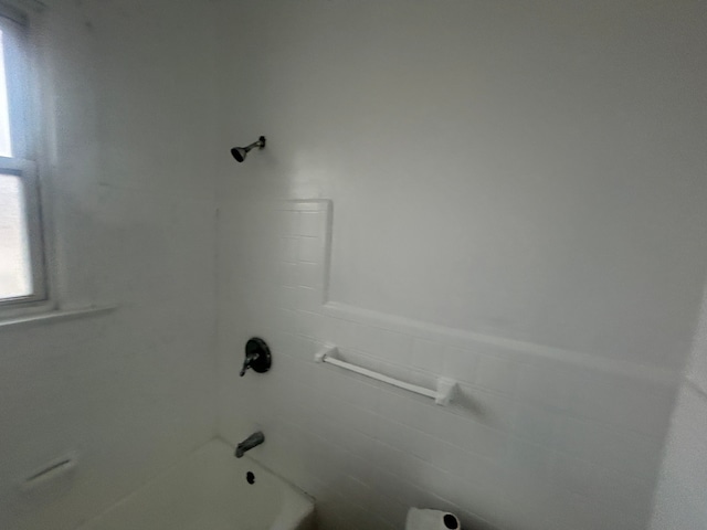 full bathroom featuring wainscoting, tile walls, and  shower combination