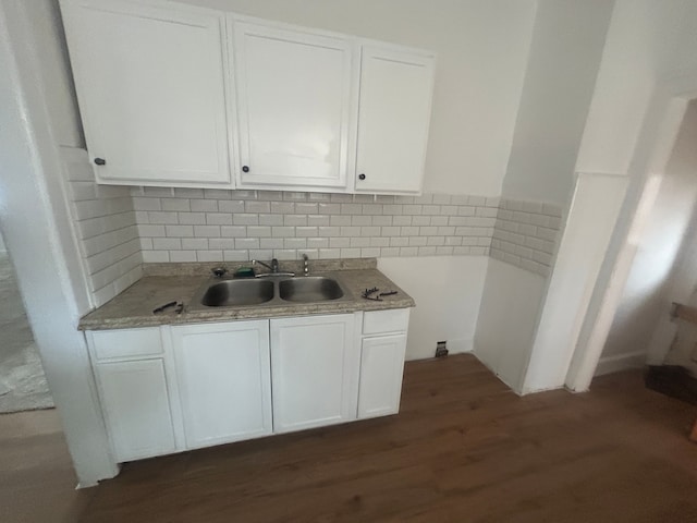 kitchen featuring dark wood-style flooring, white cabinetry, light countertops, and a sink