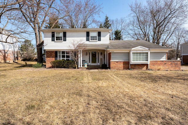 traditional home with brick siding and a front yard