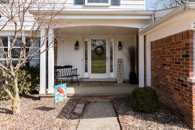 property entrance with brick siding and covered porch