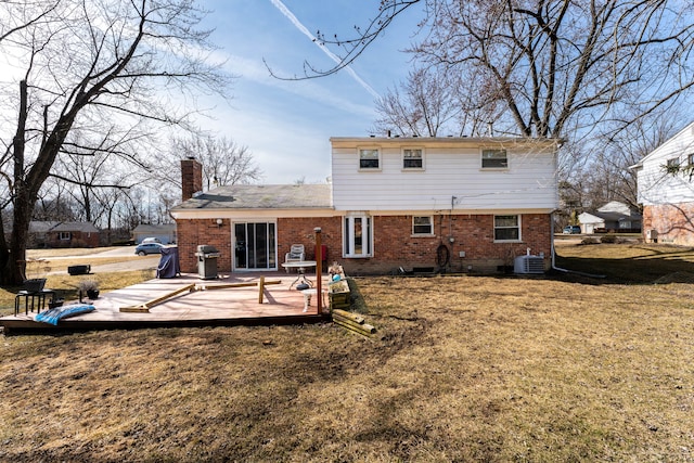 back of property featuring a lawn, cooling unit, a wooden deck, brick siding, and a chimney