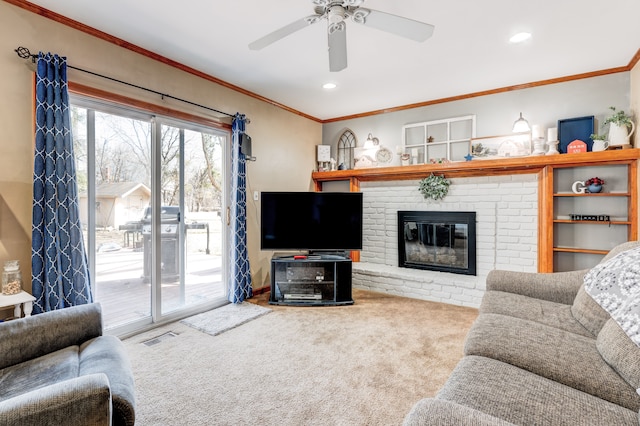 living area featuring visible vents, a brick fireplace, crown molding, carpet, and recessed lighting