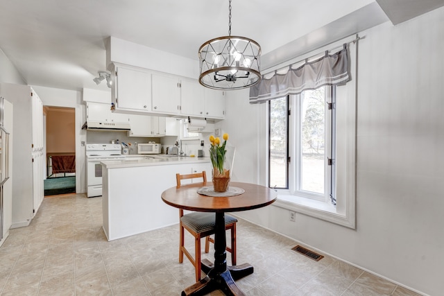 dining area featuring visible vents and a chandelier