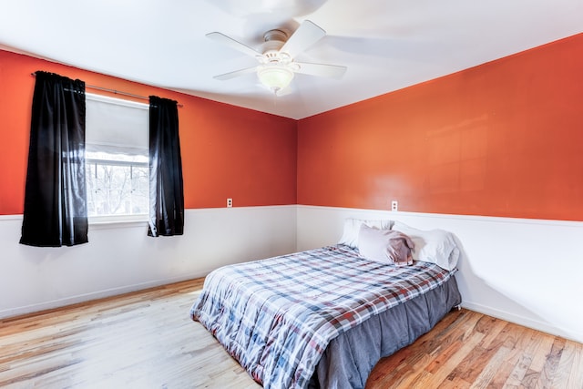 bedroom featuring wood finished floors, baseboards, and ceiling fan