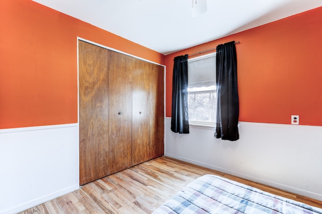 unfurnished bedroom featuring a closet, baseboards, and wood finished floors