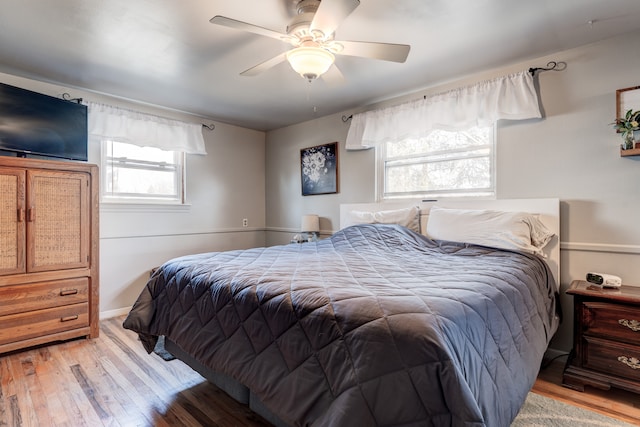 bedroom featuring light wood-style flooring, baseboards, and ceiling fan