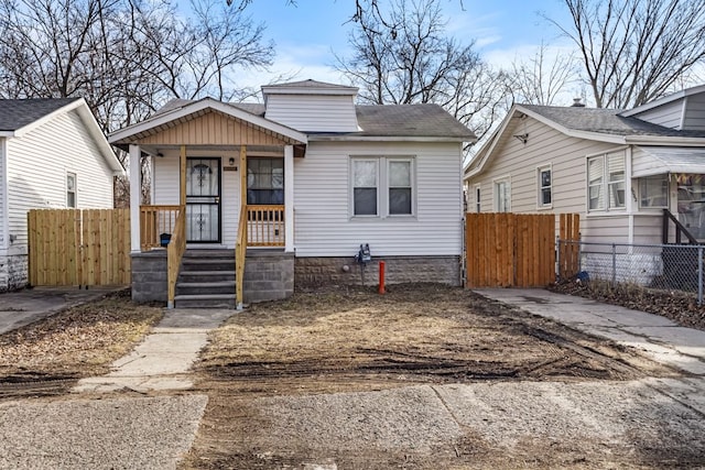 bungalow-style house with covered porch and fence