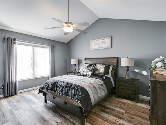 bedroom featuring ceiling fan, baseboards, wood finished floors, and vaulted ceiling