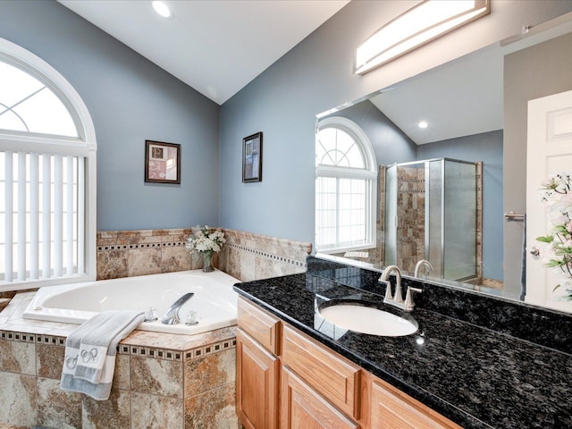 full bath with a garden tub, a stall shower, vanity, and lofted ceiling