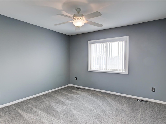 spare room featuring visible vents, baseboards, carpet, and a ceiling fan