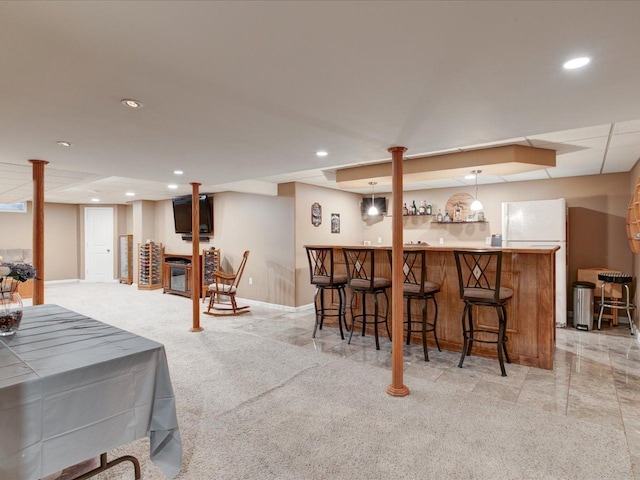 bar featuring bar area, recessed lighting, baseboards, light colored carpet, and hanging light fixtures