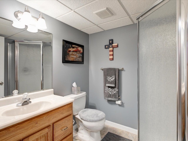 full bath featuring vanity, visible vents, a drop ceiling, a shower stall, and toilet