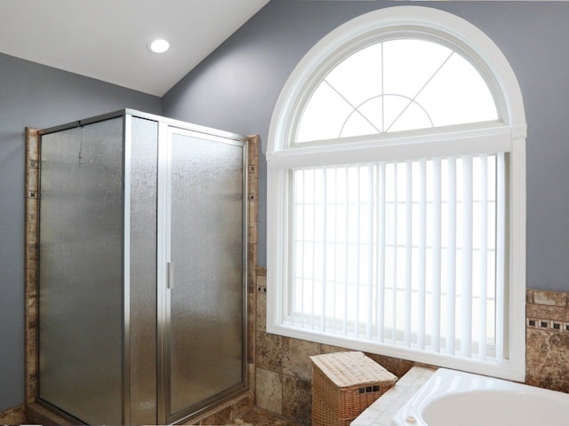 bathroom featuring a garden tub and a shower stall