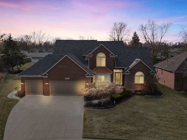 traditional home featuring concrete driveway, a front yard, a shingled roof, a garage, and brick siding