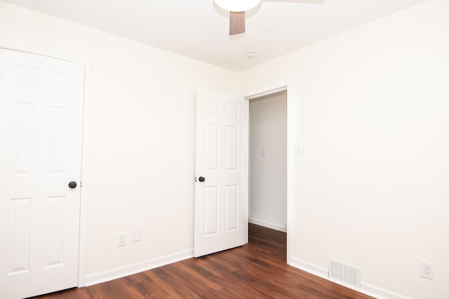 unfurnished bedroom with visible vents, ceiling fan, baseboards, and dark wood-style flooring