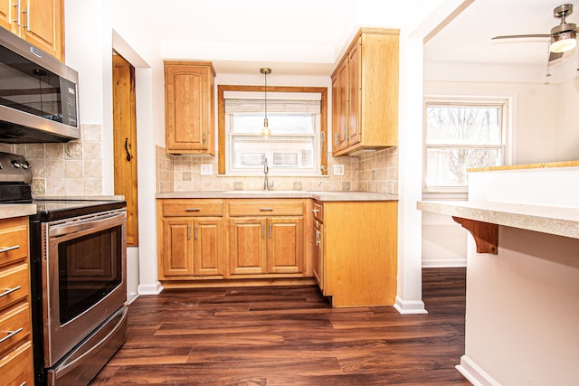 kitchen featuring dark wood finished floors, appliances with stainless steel finishes, light countertops, and a sink