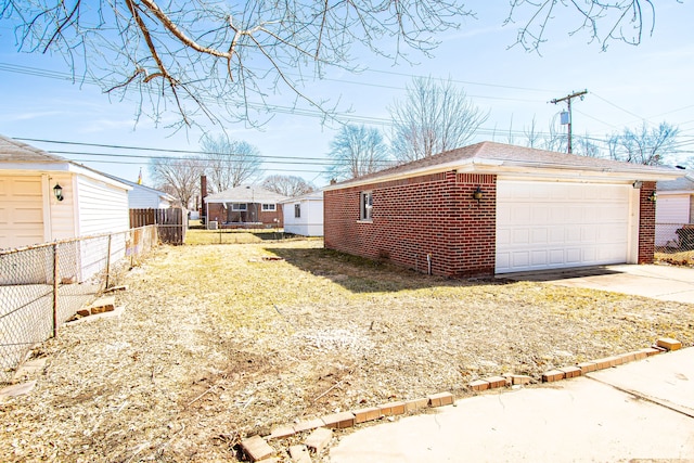 view of side of home with brick siding, an outbuilding, fence, and a garage