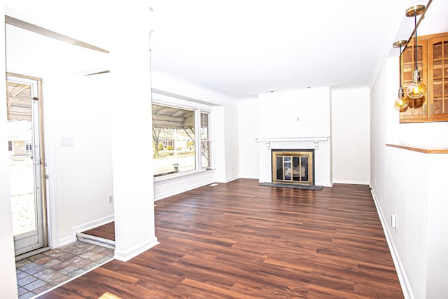 unfurnished living room with a glass covered fireplace, baseboards, and wood finished floors