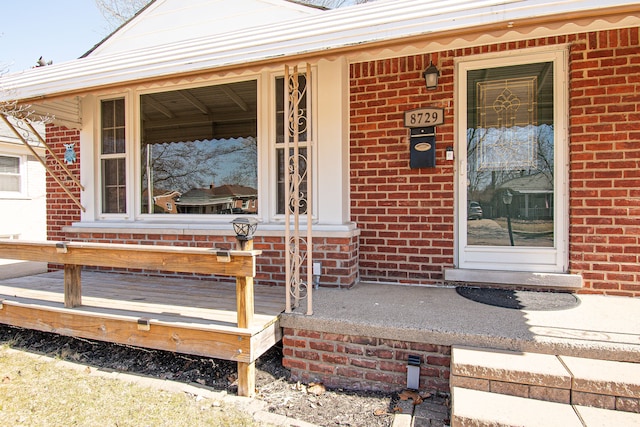 property entrance with brick siding and covered porch