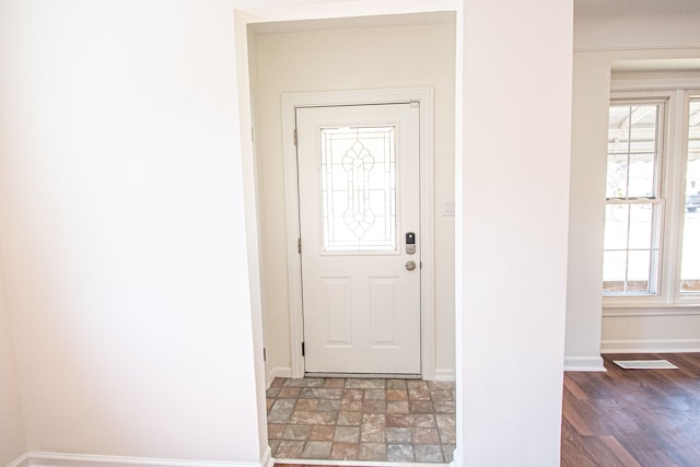 doorway with baseboards and wood finished floors