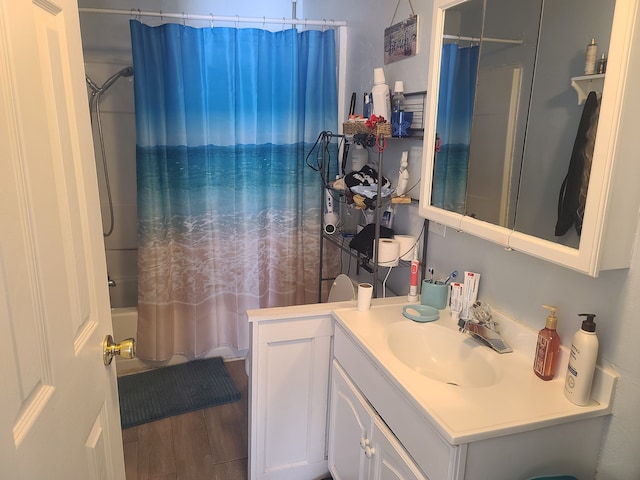 full bath featuring vanity, wood finished floors, and shower / tub combo with curtain