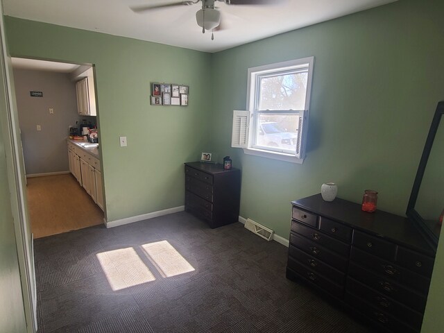 bedroom featuring a ceiling fan, visible vents, baseboards, and dark colored carpet