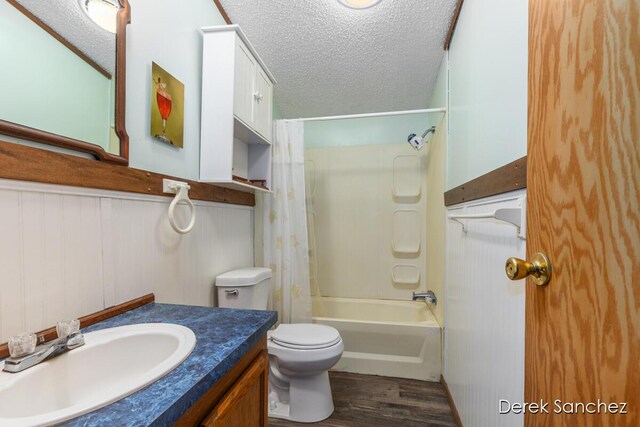 full bathroom with vanity, toilet, wood finished floors, and a textured ceiling