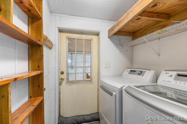 washroom with laundry area, washing machine and dryer, and a textured ceiling