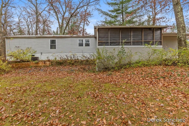 back of property featuring central air condition unit and a sunroom