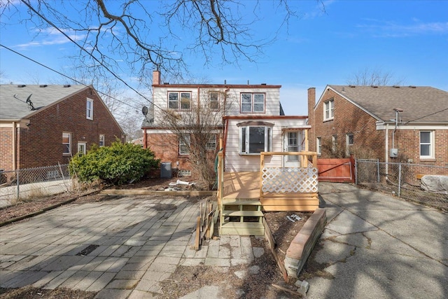 rear view of property featuring central AC, a chimney, a deck, and fence