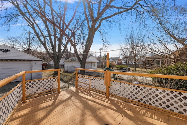 wooden deck featuring a residential view, an outbuilding, and fence