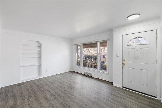 foyer featuring visible vents, baseboards, and wood finished floors