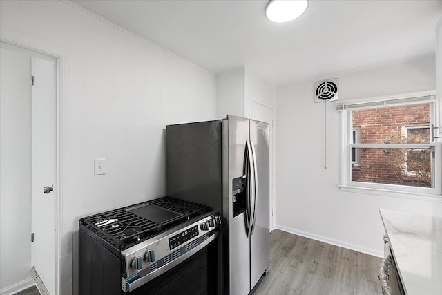 kitchen featuring visible vents, appliances with stainless steel finishes, light wood finished floors, baseboards, and light stone countertops