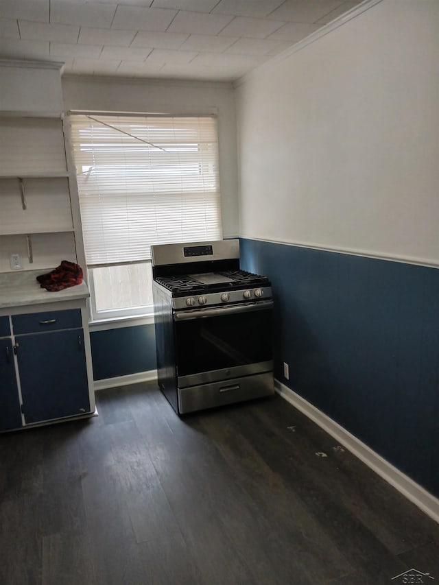 kitchen featuring ornamental molding, dark wood-style floors, gas stove, light countertops, and baseboards