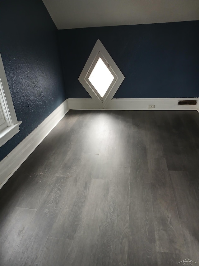 interior space with visible vents, baseboards, and wood finished floors