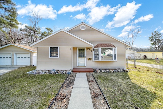 bungalow-style home featuring a detached garage, an outdoor structure, a front yard, and fence