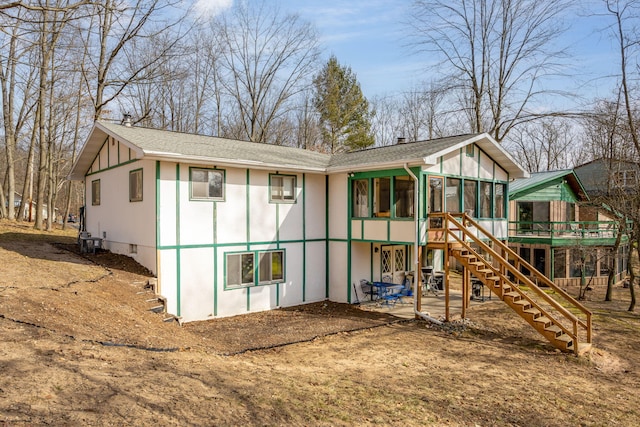 view of playground featuring stairway, a patio area, and a sunroom