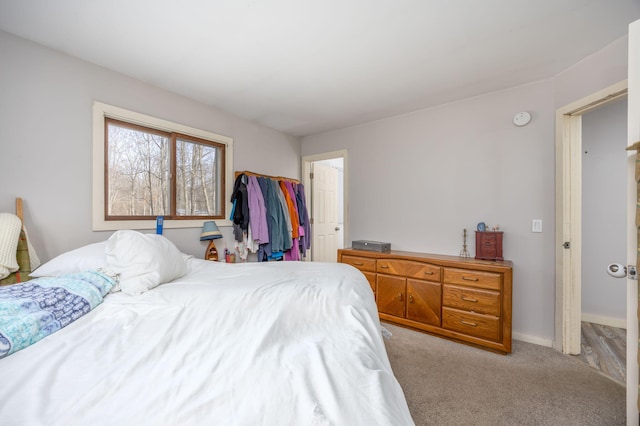 bedroom featuring light carpet, a closet, and baseboards