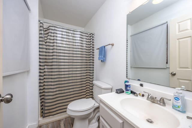 full bathroom featuring a shower with shower curtain, toilet, vanity, and wood finished floors