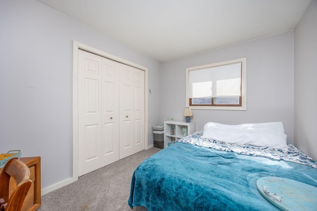 carpeted bedroom with a closet and baseboards