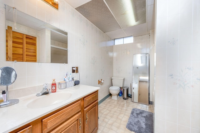 full bathroom with vanity, tile walls, and a shower stall