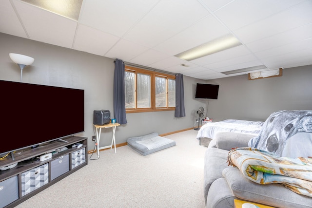 carpeted bedroom with baseboards and a drop ceiling